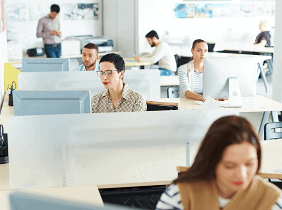 Office workers at desks with computers in an open office