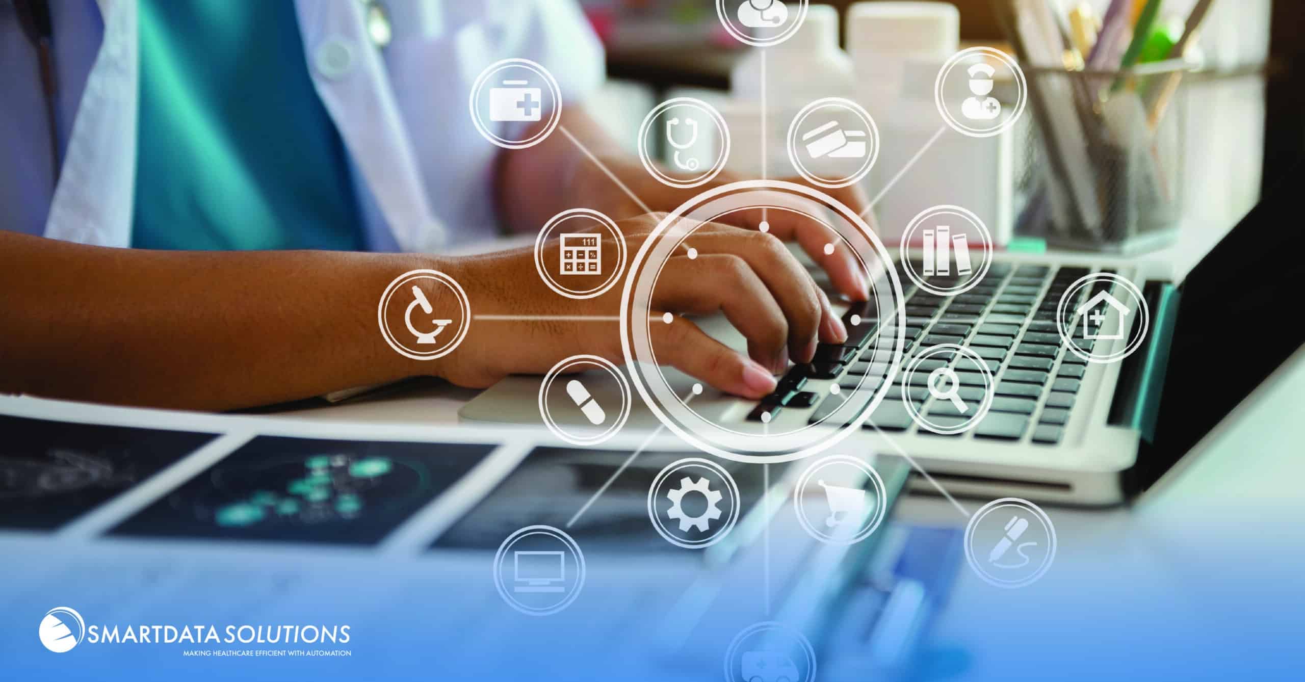 Medical icons in a ring around hands typing on a laptop, representing healthcare interoperability