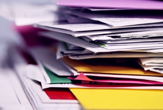 Stack of paper mail and colored envelopes