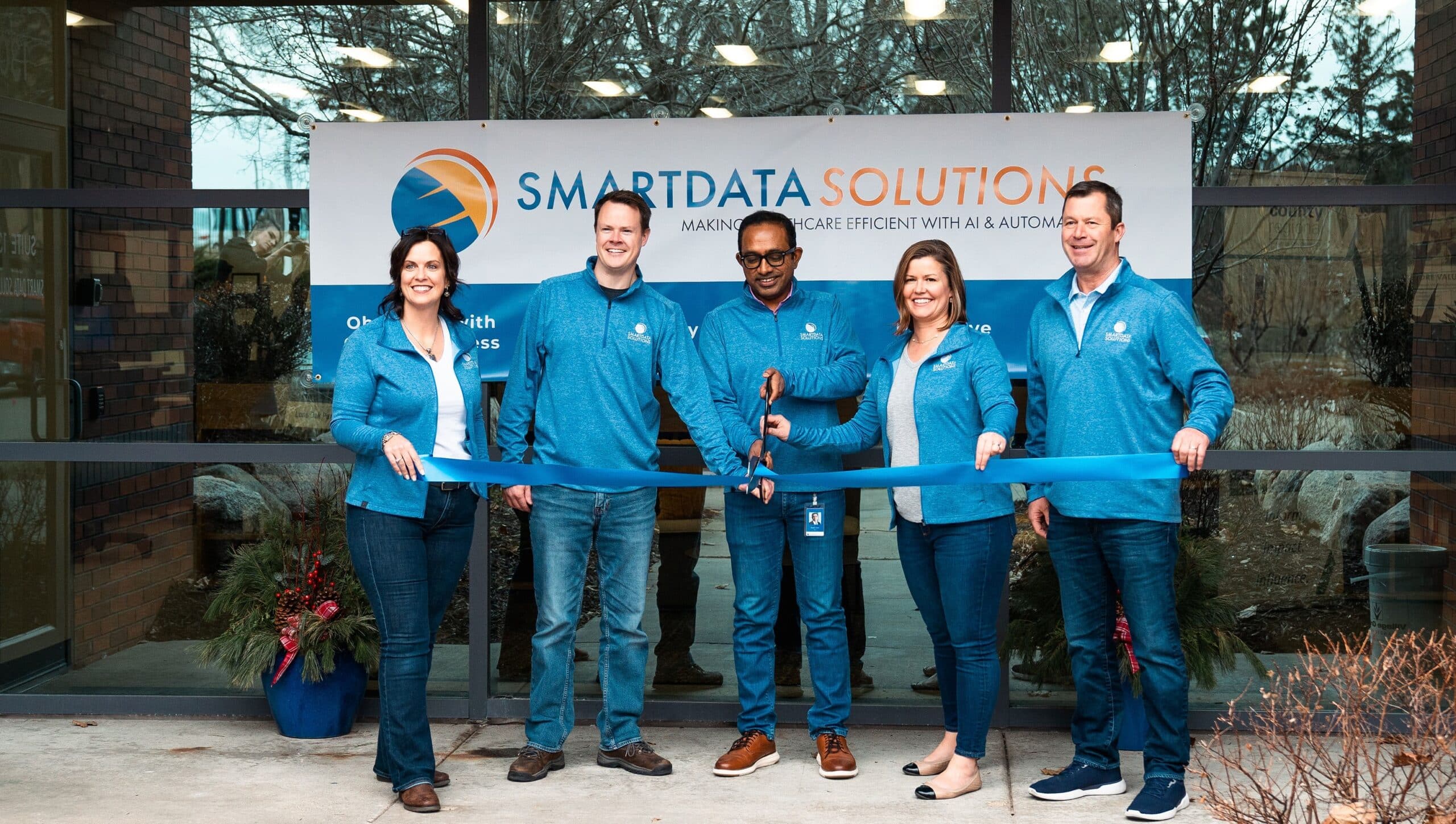 Smart Data Solutions leaders cutting a ribbon at the opening of the new global headquarters