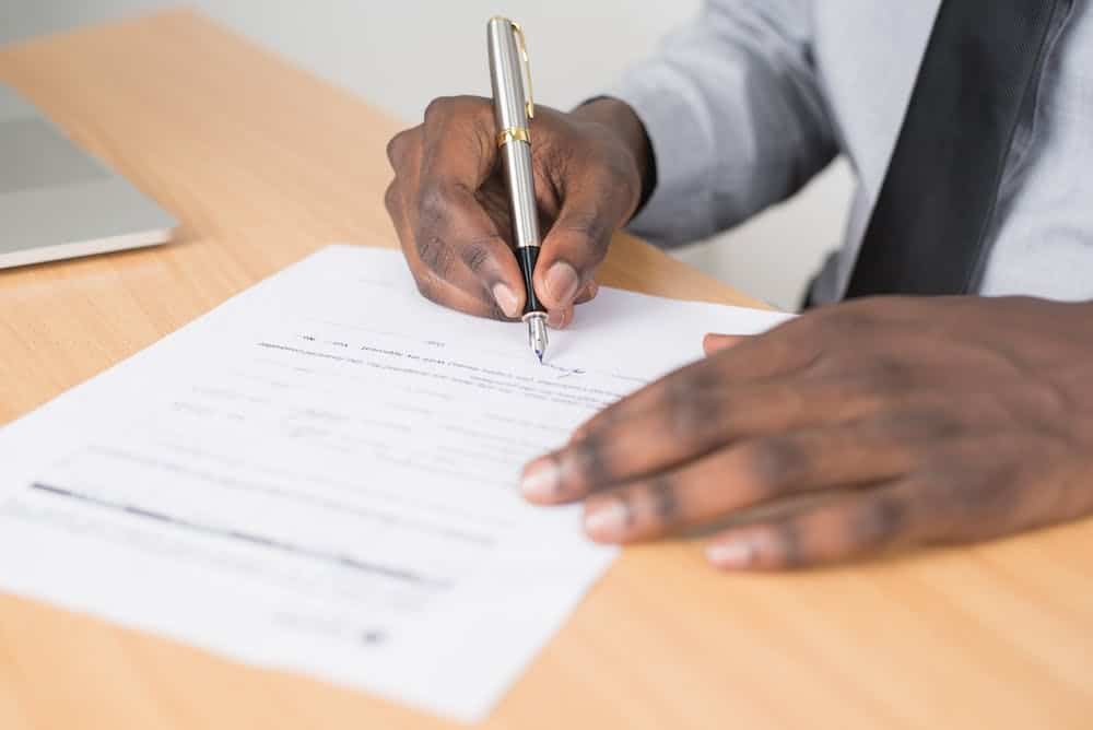 Hand signing a document with a fountain pen