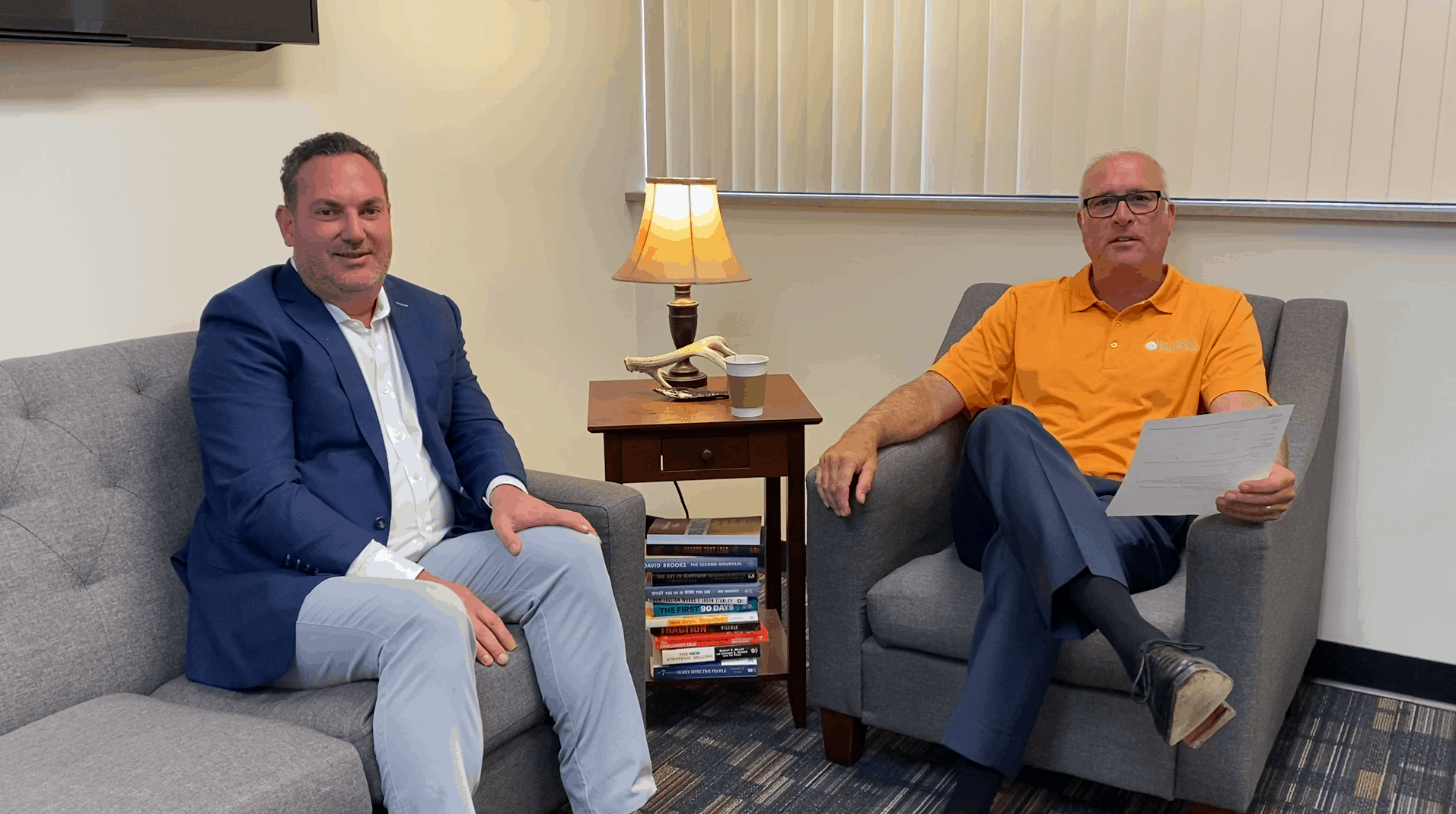Two men seated in armchairs having a conversation about clearinghouse solutions