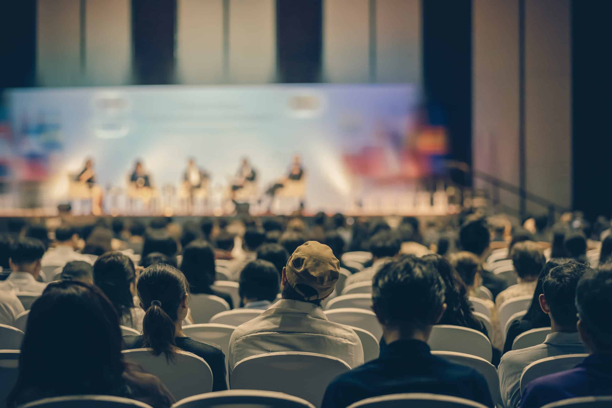 Audience watching a panel discussion on stage at a conference